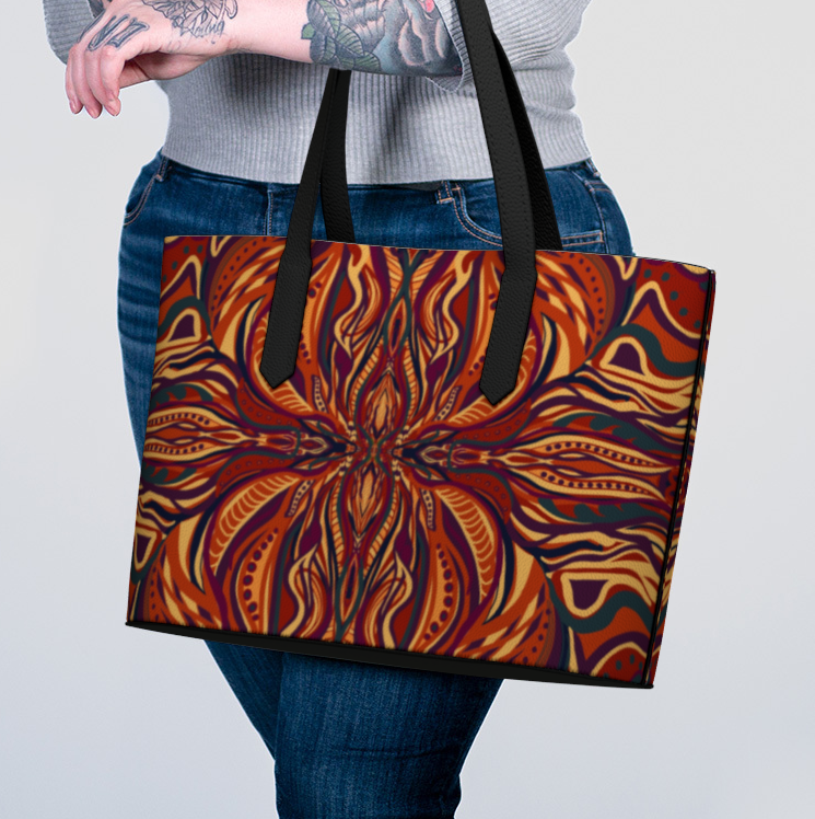 Person holding a tote bag with a colorful abstract design on a plain background