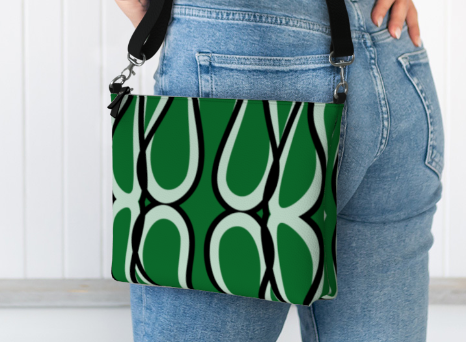 Person holding a green and white patterned bag with a plain background
