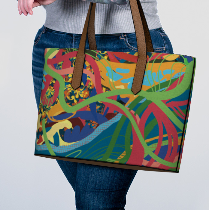 Person holding a colorful tote bag with a pattern on a plain background