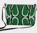 Green handbag with black abstract pattern on a light gray background